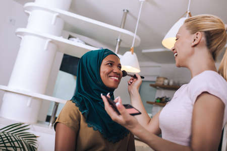 A make-up artist makes up a Muslim woman at home.