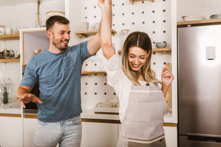 Young beautiful couple in kitchen having fun.の写真素材
