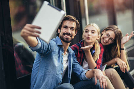 Group of friends taking selfie with tablet pc