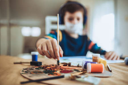 Cute little boy painting a picture in home studioの写真素材