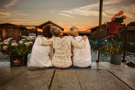 Senior female friends enjoying a evening in the cottage near the riverの写真素材