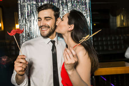 Portrait of happy young couple posing together at nightclub