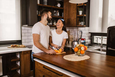 Couple making fresh organic juice in kitchen togetherの写真素材