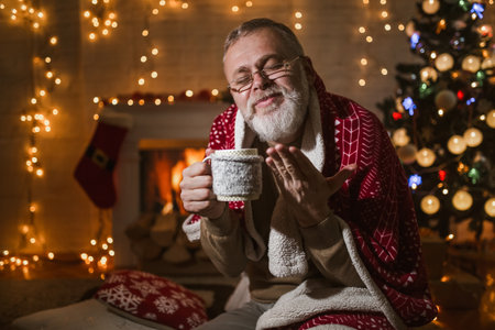 Man sitting and relaxation near fireplace and christmas tree.の写真素材