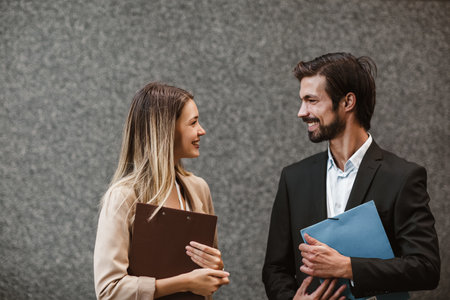 Office colleagues talking outdoors near the office building, discussing new project.の写真素材