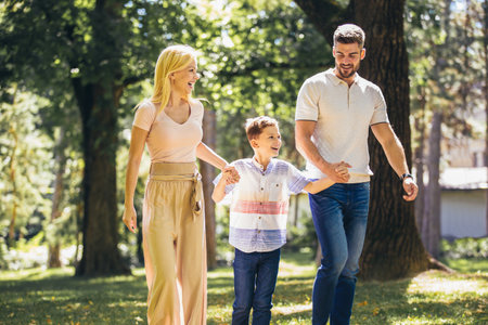 Young happy family with one children in the summer park