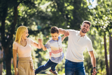 Young happy family with one children in the summer parkの写真素材