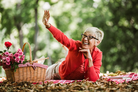 Portrait of senior woman at picnic in parkの写真素材