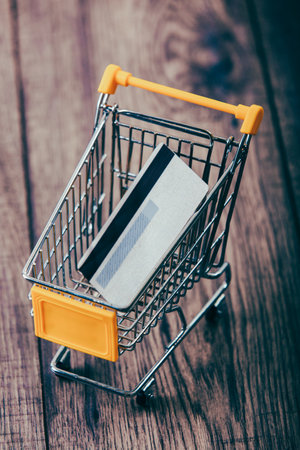 Small shopping cart with credit card inside- concept use credit for shopping.の写真素材