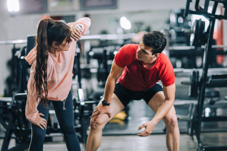 Fitness instructor with girl on training in fitness centerの写真素材