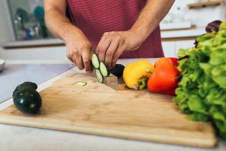 Chef cuts the vegetables into a meal. Preparing dishes. Man uses a knife and cooks.の写真素材