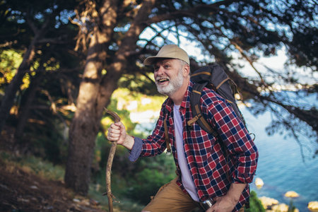 Mature man, hiking by the sea and exploring the natureの写真素材