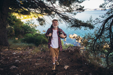 Mature man, hiking by the sea and exploring the natureの写真素材