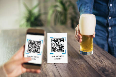 Women's hands are using the phone to scan the qr code to select menu. Scan to get discounts or pay...