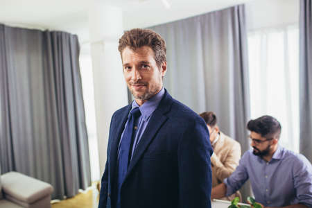 Leader ceo or professional business coach looking at camera posing in office with diverse happy team...