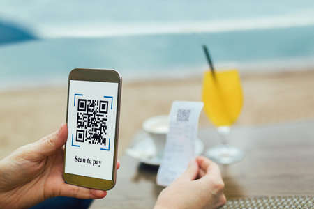 Women's hands are using the phone to scan the qr code to pay juice and coffee. Scan to get discounts or pay for juice.の写真素材