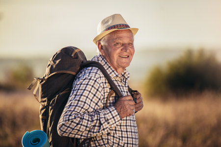 Happy old man just reaches the top of hill.Handsome senior man hiking, exploring.の写真素材