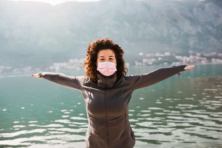 Woman wearing medical mask, Coronavirus pandemic Covid-19. Sport, Active life in quarantine. Outdoor run on athletics track in Corona Outbreak.の写真素材