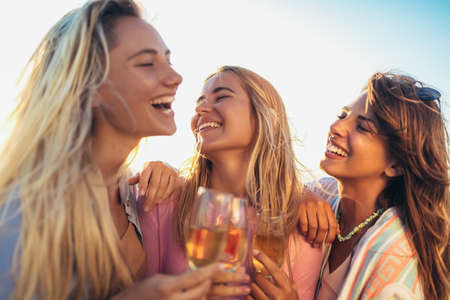 Friends having fun with champagne at celebration on beachの写真素材