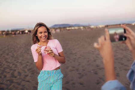 Girl eating ice cream on the beachの写真素材