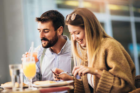 Young couple sitting in a restaurant eating pizza