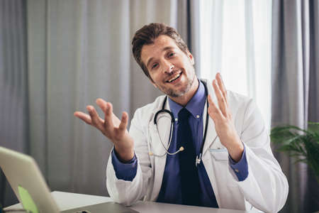 Portrait of male, doctor sitting in medical office.の写真素材