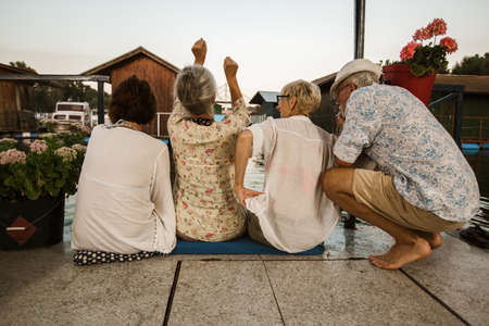 Senior friends enjoying a day in the cottage near the riverの写真素材