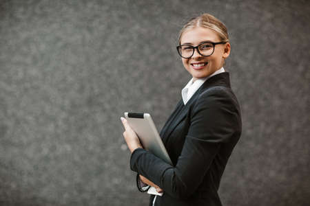 Businesswoman working on digital tablet outdoor over building backgroundの写真素材