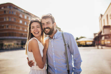Couple in love walking embracing in street on romantic tripの写真素材