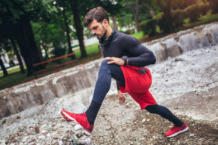 Man runner training. Male athlete stretching muscles at the park. Healthy, fitness, wellness...