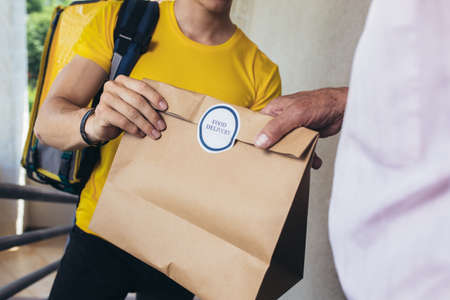 Young male volunteer delivering shopping to senior man. Donationの写真素材