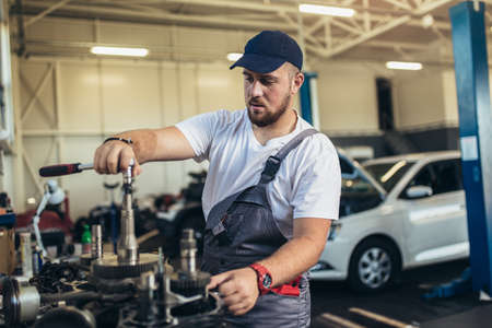 Technician working on checking and service car in workshop garage; technician repair and maintenance...