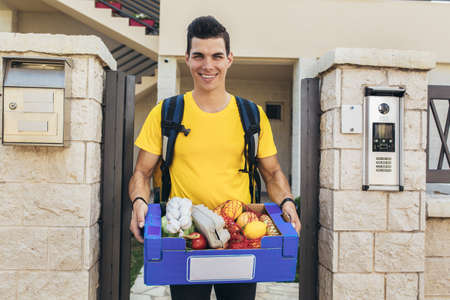 Young man delivering online grocery order.の写真素材