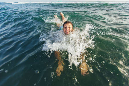 Child swim in the sea and have fun. Selective focusの写真素材