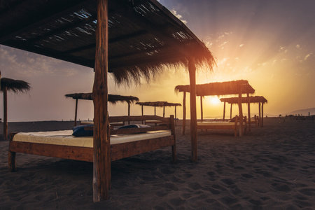 Sandy beach with sun beds at sunsetの写真素材