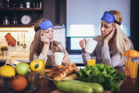 Happy mother and daughter at home kitchen and spend time together in the morningの写真素材