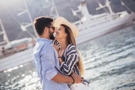 Happy young couple laughing and hugging on the beachの写真素材