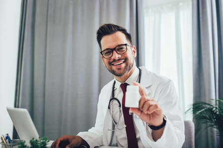 Young male doctor recommended pills bottleの写真素材