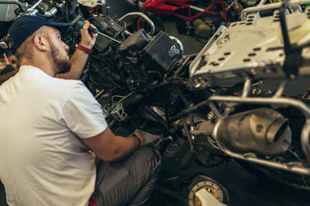 Professional motorcycle mechanic working in bike repair serviceの写真素材