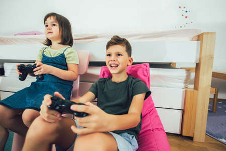 Happy children - girl and boy playing a video gameの写真素材