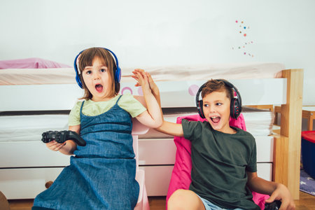Happy children - girl and boy playing a video gameの写真素材