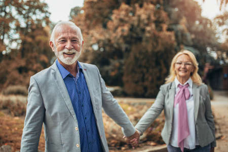 Happy senior couple in autumn parkの写真素材