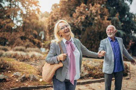 Happy senior couple in autumn parkの写真素材