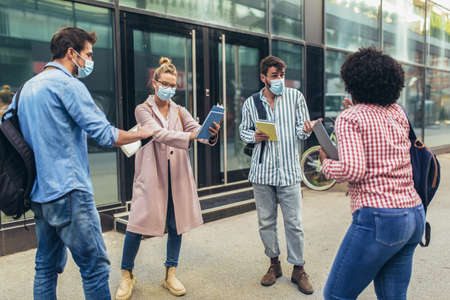 Distance learning. Social distance. New normal life. University students standing outdoor.の写真素材