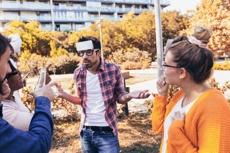 Group of young people hangout in the park.They are play guess who game.の写真素材