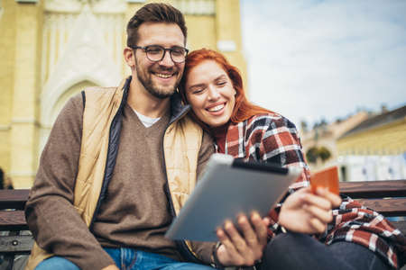 Trendy young couple in town using tablet and credit card.の写真素材