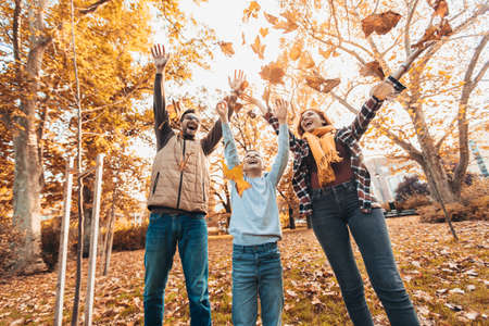 Portrait of a happy family having fun in the autumn park.の写真素材