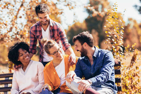 Group of young people having fun outdoors on park benchの写真素材