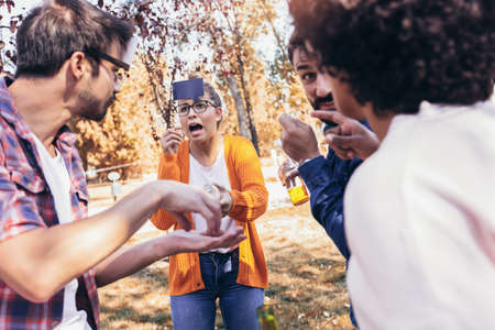 Group of young people hangout in the park.They are play guess who game.の写真素材