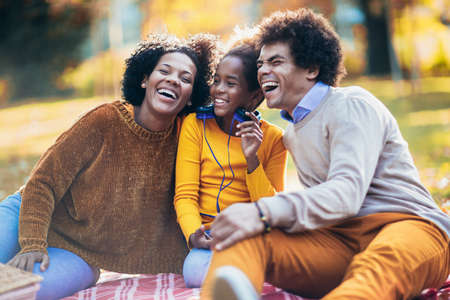 Mixed family having fun while picnicking in the parkの写真素材